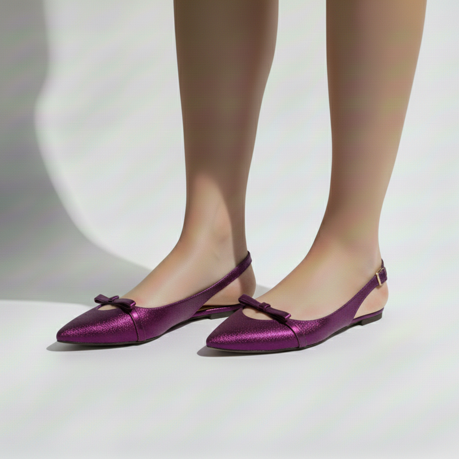 Purple flat shoes with a bow detail worn by a person on a white background