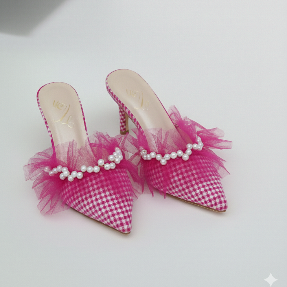 Pair of pink gingham high-heeled shoes with tulle and pearls on a white background