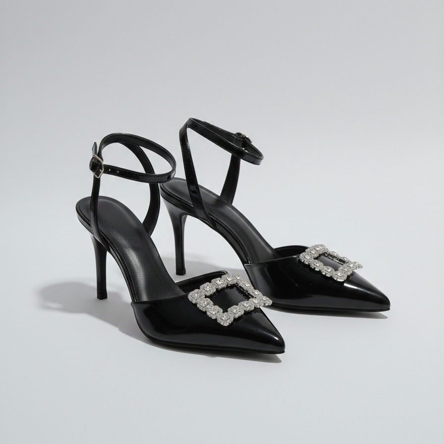 Black high-heeled shoes with decorative buckles on a light gray background