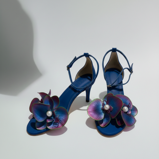 Blue high-heeled shoes with floral designs on a white background
