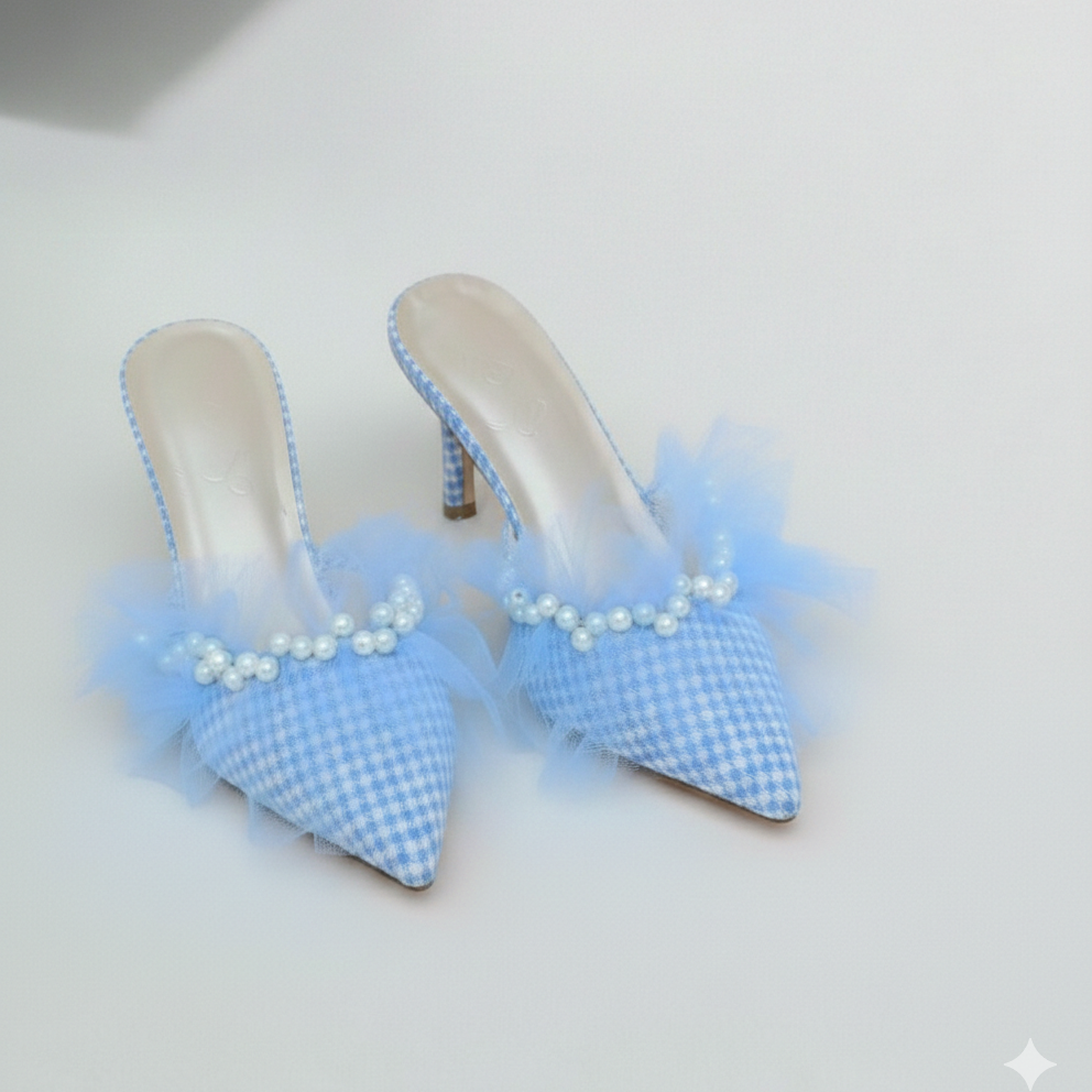 Pair of light blue checkered high-heeled shoes with tulle and pearls on a white background