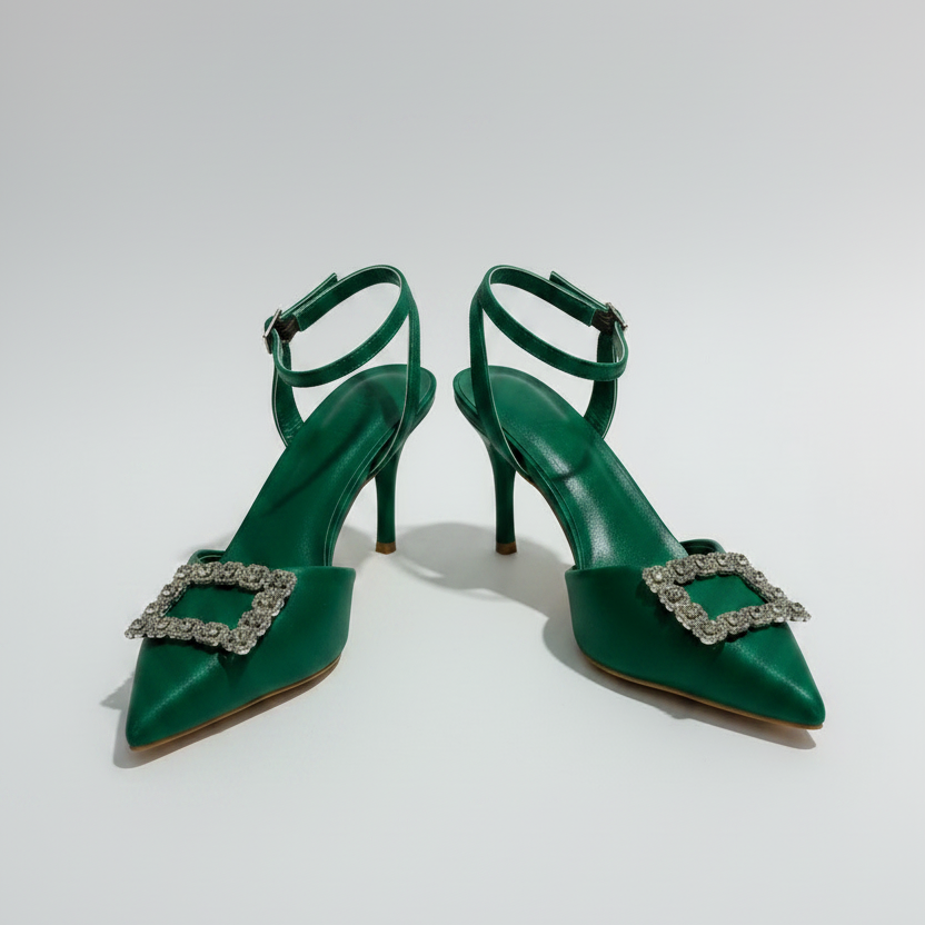 Pair of bright green high-heeled shoes with embellishments on a white background