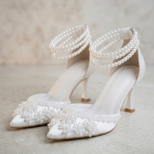 White wedding shoes with pearl embellishments on a neutral background