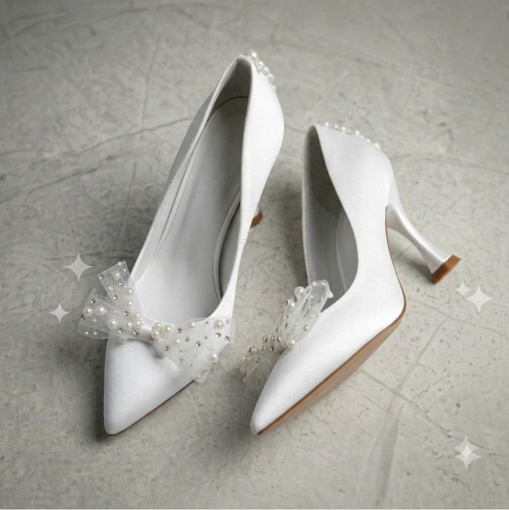 White high-heeled shoes with decorative bows on a light gray background