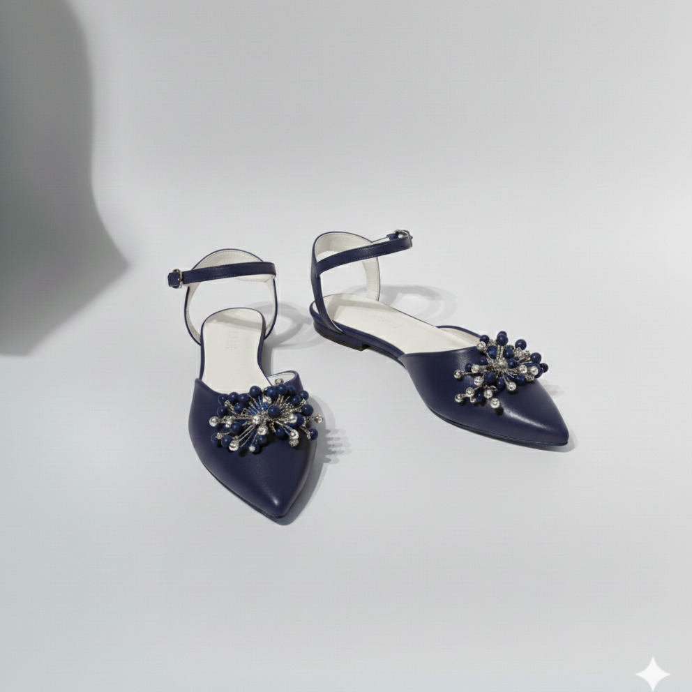 Navy blue pointed-toe shoes with embellishments on a light gray background