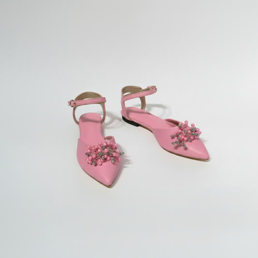 Pair of pink shoes with floral embellishments on a white background