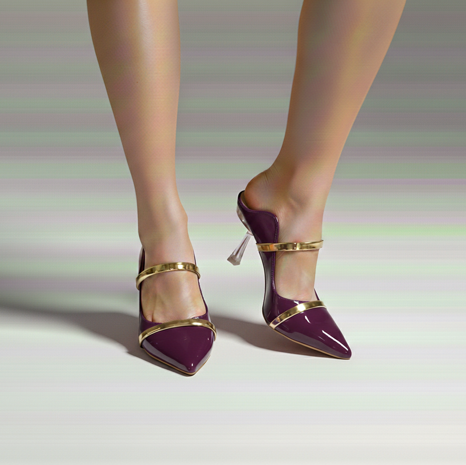 Purple high-heeled shoes with gold straps worn by a person on a light background